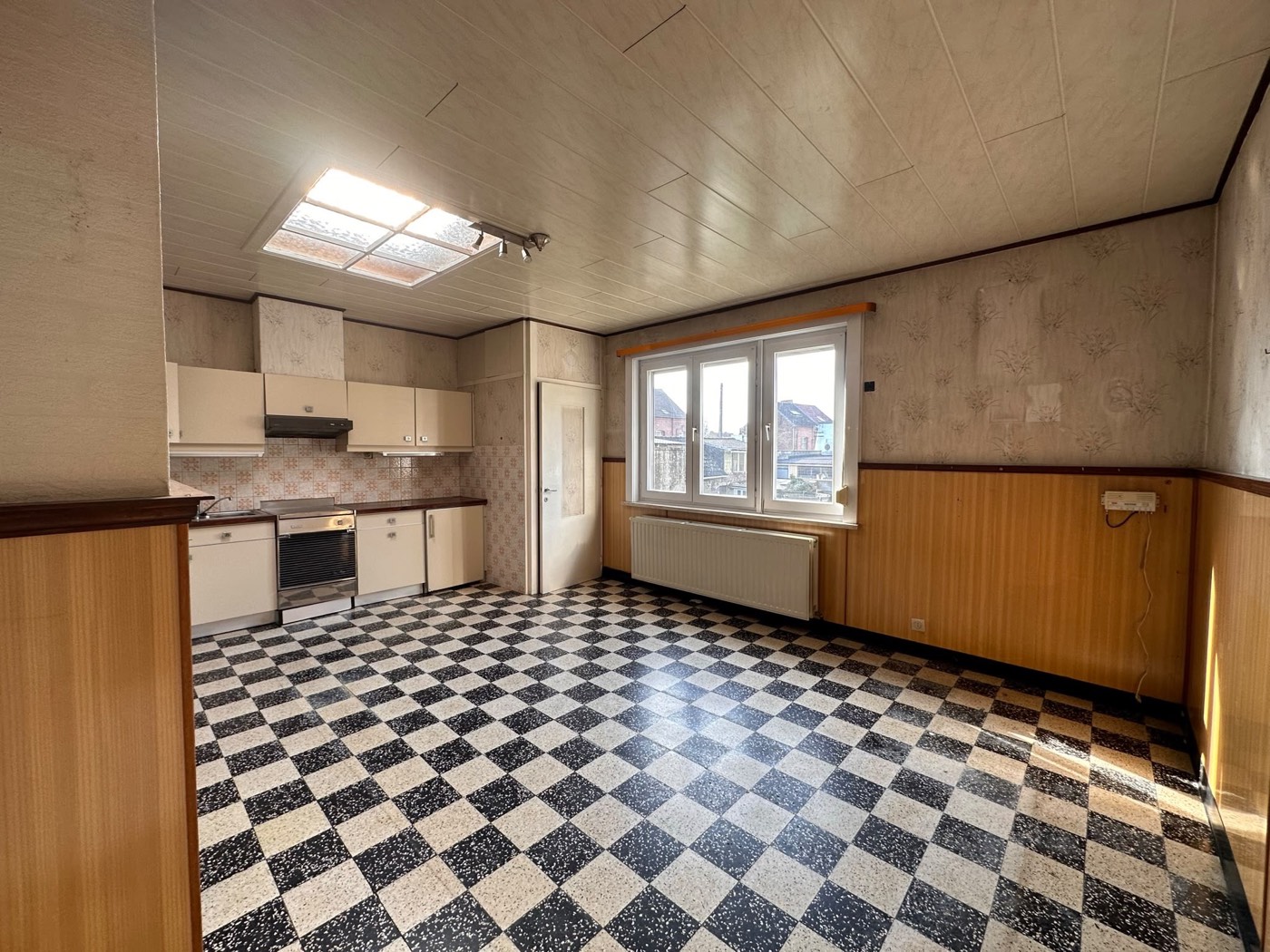 Ancienne cuisine avec sol damier avant rénovation complète