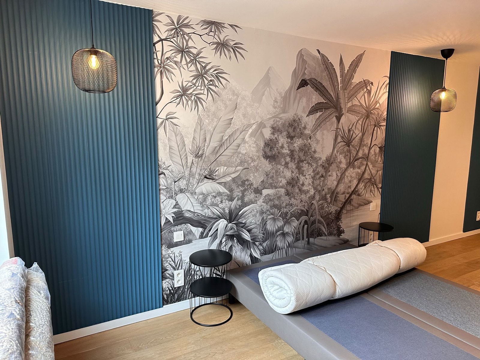 Chambre avec mur cannelé bleu et fresque murale végétale