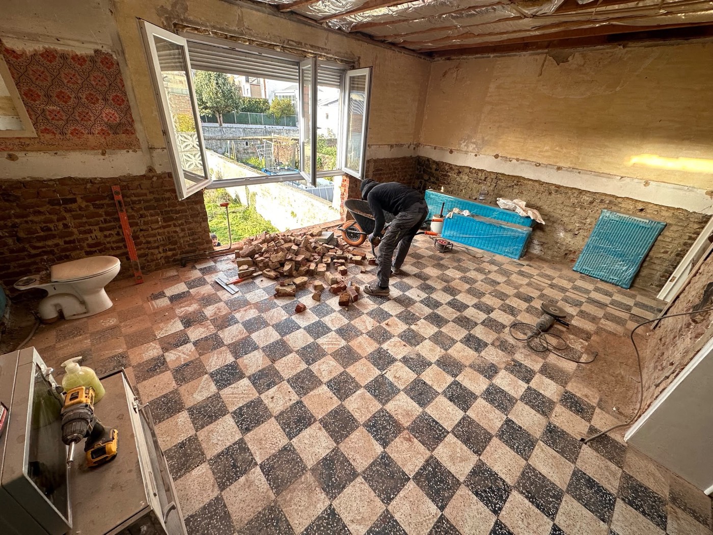 Dépose de l'ancien carrelage damier avant pose du nouveau sol