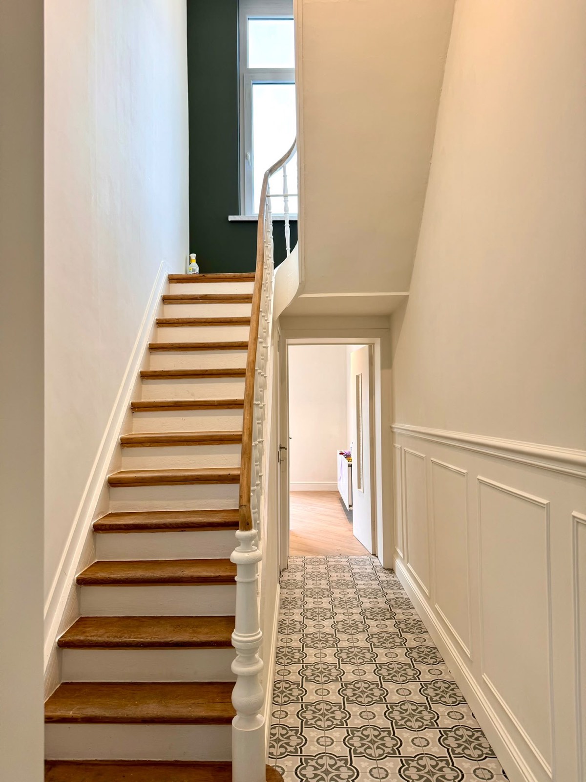 Cage d'escalier rénovée avec marches bois et soubassement peint