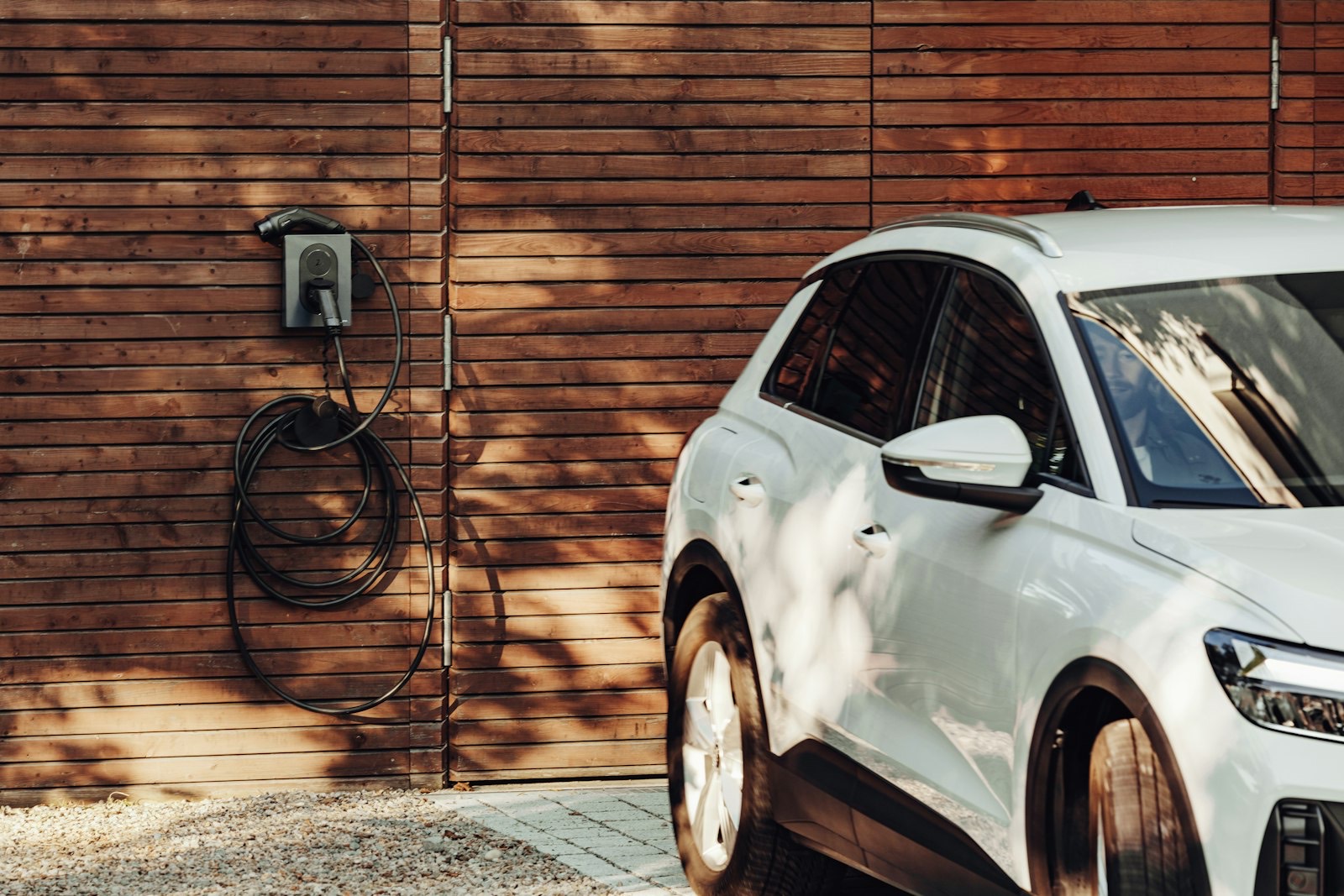 Borne de recharge pour véhicule électrique posée sur la façade d'une maison
